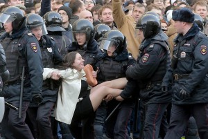 Džentlmenští policisté přenášejí mladou ženu přes velkou kaluž, aby si nezašpinila oblečení.